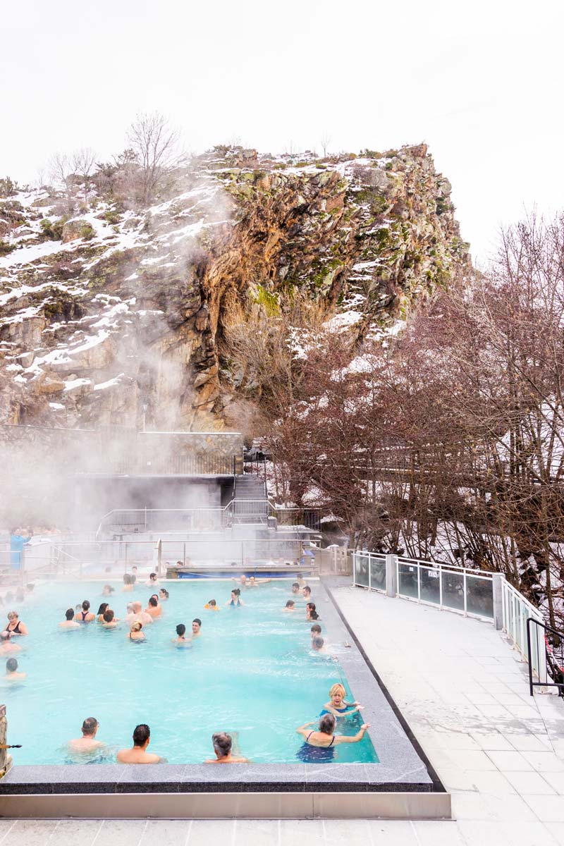 ensemble de personnes profitant de la piscine extérieur en hiver avec une montagne eneigé derriere